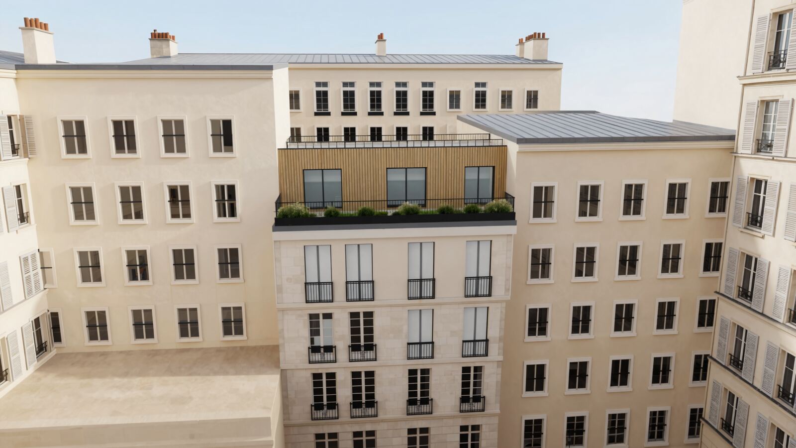 L'immeuble de Paris vu depuis la cour, avec un attique en bois en retrait derrière une terrasse plantée.